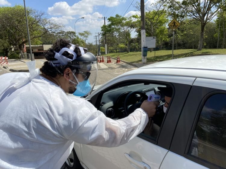 De carro ou a pé, todos passam pela medição da temperatura